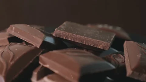 Pieces of dark chocolate on a rotating platform Stock Footage 165991255