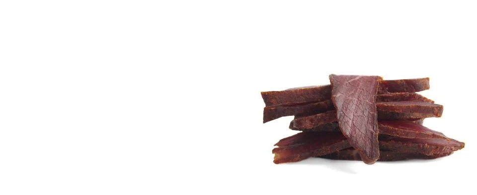 Pieces of delicious beef jerky on white background. Banner design Stock Photos
