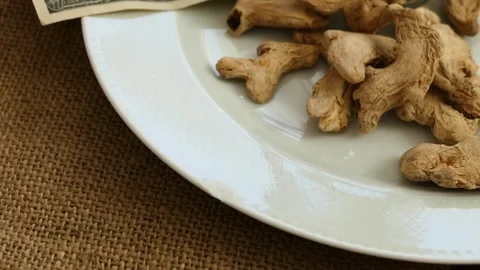 Pieces of dried ginger on a ground and $ 100 usd, Stock Footage 132217455