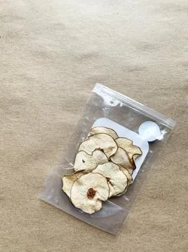 Pieces of dried pear in plastic packaging on craft paper background. Foto stock
