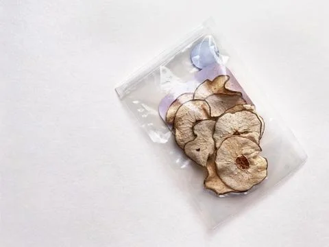 Pieces of dried pear in plastic packaging on white Foto stock