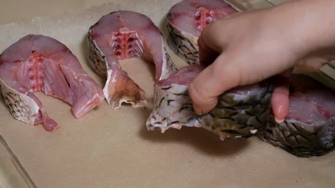 Pieces of fish on parchment. Preparation for baking dinner in the oven Vídeos de archivo 103488512