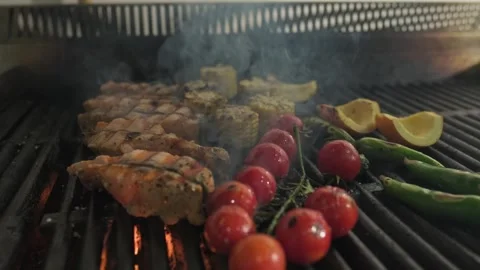 Pieces of fish, tomatoes and vegetables are grilled on the barbecue grate with Stock Footage 254555757
