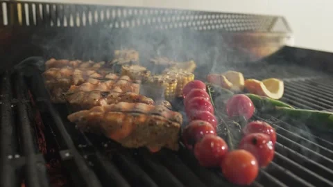 Pieces of fish, tomatoes and vegetables are grilled on the barbecue grate with Stock Footage 270727644