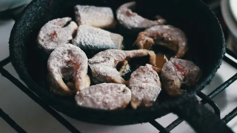 Pieces of fresh fish are fried in a frying pan in flour and they are turned with Vídeos de archivo 74281761