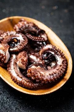 Pieces of fresh octopus. On a black background. Stock Photos