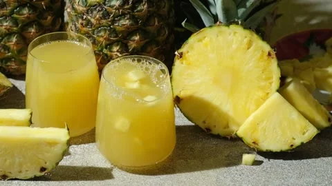 Pieces of fresh pineapple fall into pineapple juice, juice splash slow motion. Stock Footage 296327336