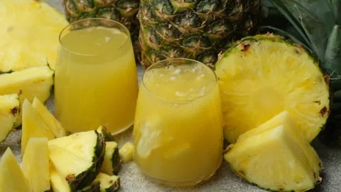 Pieces of fresh pineapple fall into pineapple juice, juice splash slow motion. Stock Footage 296372141