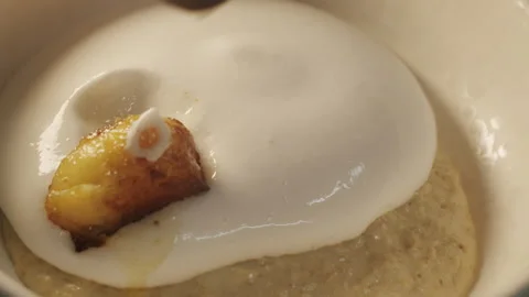 Pieces of fried banana are added on top of the coconut mousse cream Stock Footage