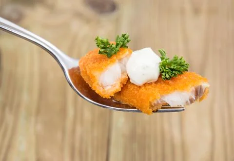 Pieces of fried fish on a fork Stock Photos