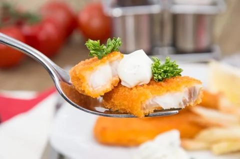 Pieces of fried fish on a fork Stock Photos