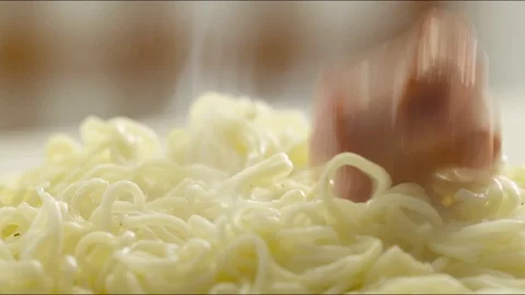 Pieces of fried sausages fall on hot noodles with steam. slow motion Video stock 86571399