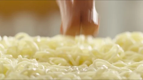 Pieces of fried sausages fall on hot noodles with steam. slow motion Video stock 86572755
