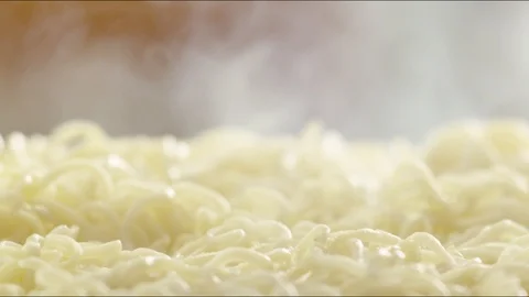 Pieces of fried sausages fall on hot noodles with steam. slow motion Video stock 86573271