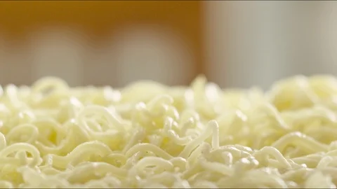 Pieces of fried sausages fall on hot noodles with steam. slow motion Video stock 86573675