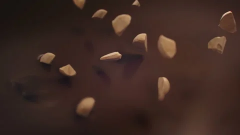 Pieces of Hazelnuts Splashing Into Liquid Dark Chocolate in 4K Super slow motion Stock-Footage 141983146