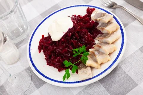 Pieces of herring with beetroot served on plate Stock Photos