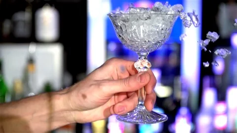 Pieces of ice fall into a glass of bartender Stock Footage 77828139
