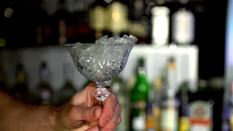 Pieces of ice fall into a glass of bartender Stock Footage 77828240