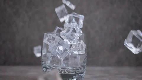 Pieces of ice fall into a glass Stock Footage 243763949