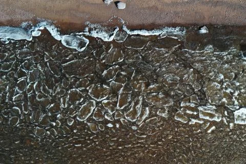 Pieces of ice float on waves, Ice plaques, sandy coast, stones, spring Foto stock