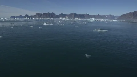 Pieces of ice floe in the Arctic Ocean with mountains in the background Video stock 103362902