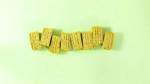 Pieces of matcha waffle covered with icing, a healthy dessert, on a green bac Foto stock