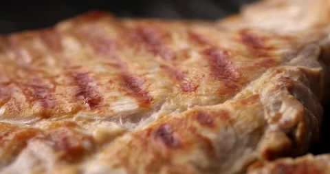 Pieces of meat are fried on a grill pan. Close-up dolly shot. Stock Footage 254065167