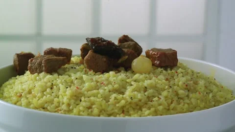 Pieces of meat are poured over bulgur rice in slow motion. Stock Footage 135191953