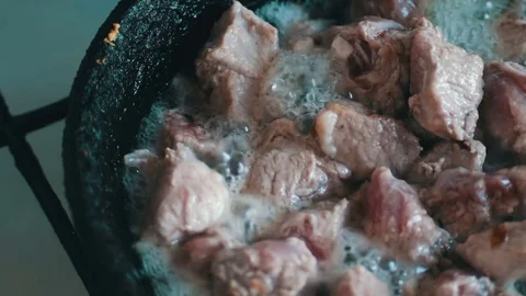Pieces of meat with blood and spices are fried in a pan Stock Footage