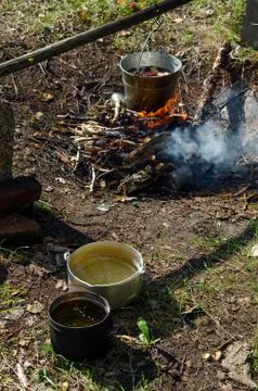 Pieces of meat float in a bucket on a campfire in the wild North of Yakutia n Stock Photos
