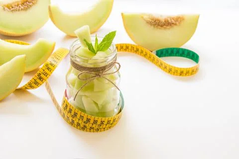 Pieces of melon in a jar and centimeter. Stock Photos