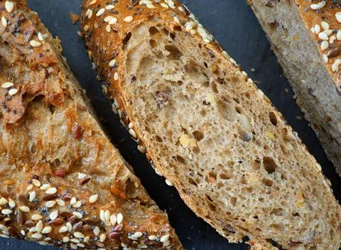 Pieces of multigrain bread on a black background. Close-up Stock-Fotos