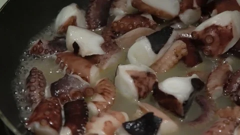 Pieces of octopus stewing in a pan. Stock Footage 104353057