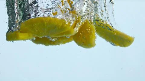 Pieces pineapple dropped water in super slow motion close up. Ananas floating. Stock Photos