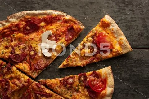 Pieces of pizza on a wooden table Stock Photos