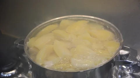 Pieces of potatoes are boiled in a pan on a gas stove. Vídeos de archivo 120948167
