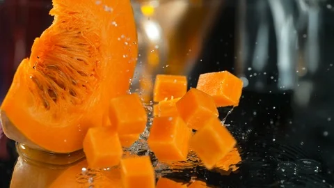 Pieces of pumpkin fall on the table  into water, SLOW MOTION, 4k, Phantom Stock Footage 114980679