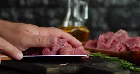 Pieces of raw beef are transferred to a plate. Stock Footage 139151544