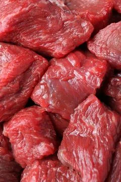 Pieces of raw beef meat as background, closeup Stock Photos