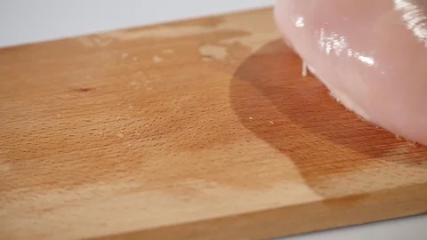 Pieces of raw chicken fillet falls on a wooden board Stock Footage