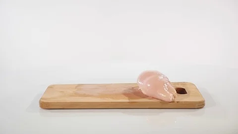 Pieces of raw chicken fillet falls on a wooden board Stock Footage 80644745