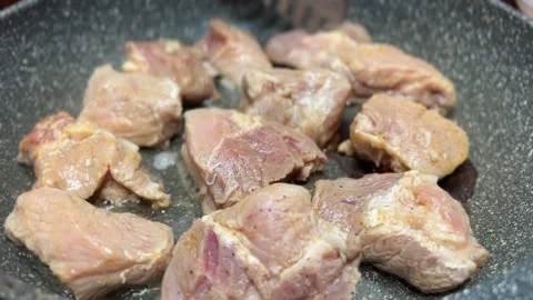 Pieces of raw meat are fried in a pot Stock Footage 232218559