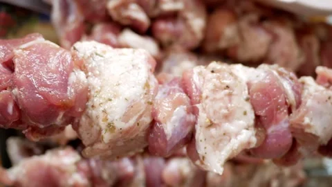 Pieces of raw pork meat on a skewer before cooking shish kebab. Stock Footage 282955587