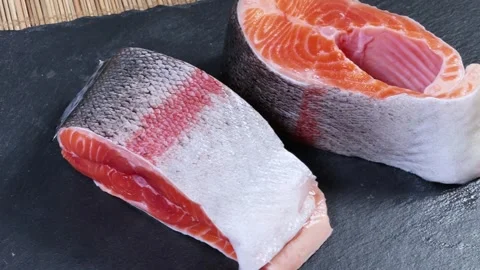 Pieces of raw rainbow trout on flat black slate plate Stock Footage 342276893