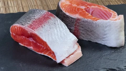Pieces of raw rainbow trout on flat black slate plate Stock Footage 342276905