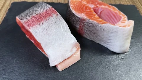 Pieces of raw rainbow trout on flat black slate plate Stock Footage 342276907