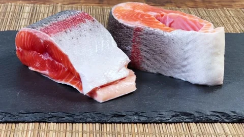 Pieces of raw rainbow trout on flat black slate plate Stock Footage 342276913
