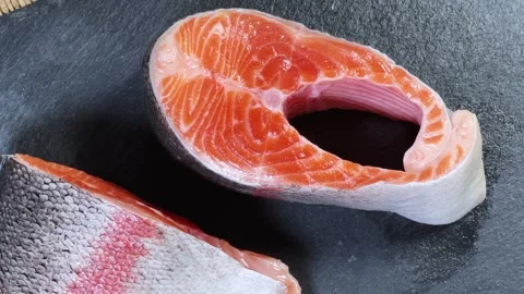 Pieces of raw rainbow trout on flat black slate plate Stock Footage 342276929