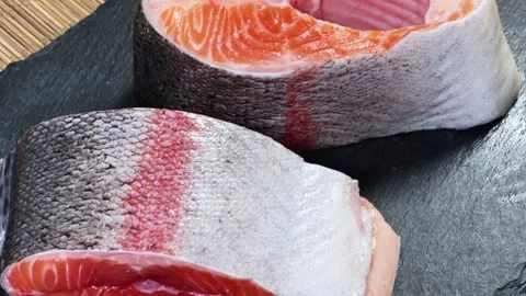 Pieces of raw rainbow trout on flat black slate plate Stock Footage 342276931